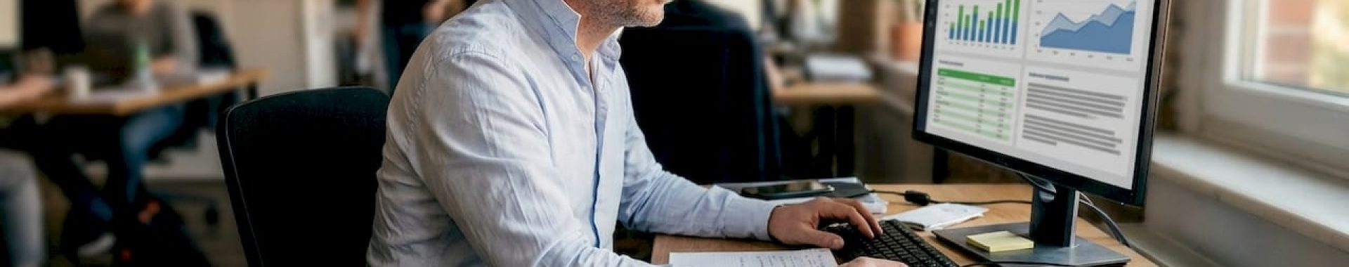 Ein Manager sitzt an einem offenen Arbeitsplatz und wertet die Ergebnisse einer Marketingkampagne aus.