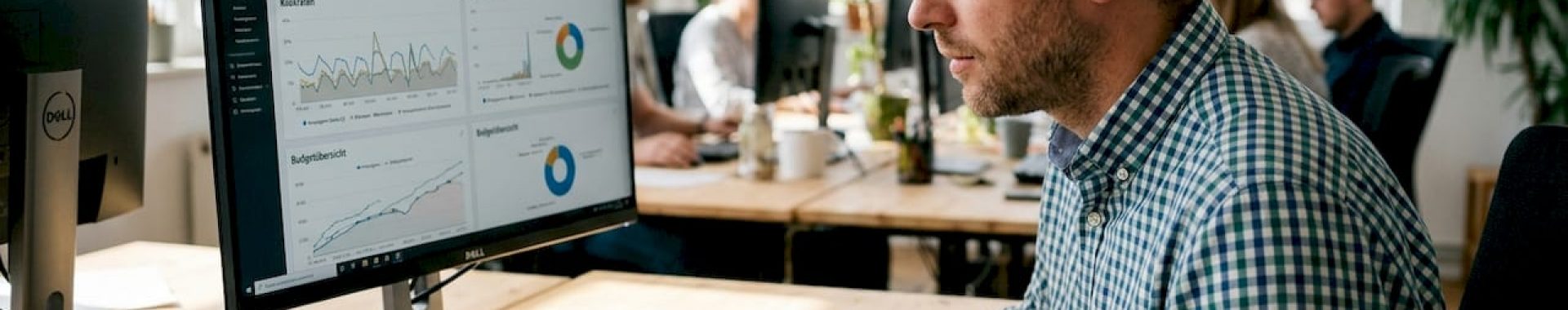 Eine Fachkraft sitzt am Schreibtisch und wertet detailliert die Werbedaten von Amazon aus.