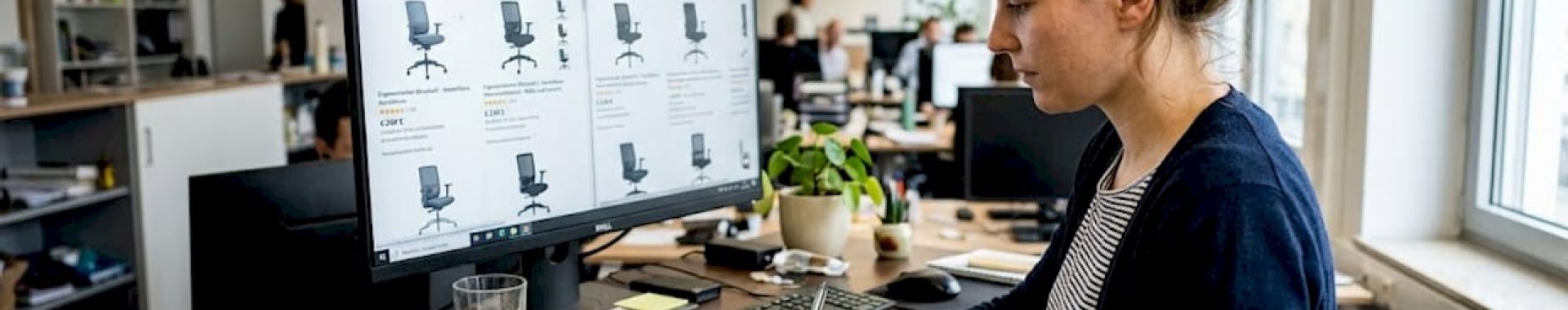 Eine Frau arbeitet konzentriert an ihrem Schreibtisch und bringt die Inhalte ihres Onlineshops auf Vordermann.