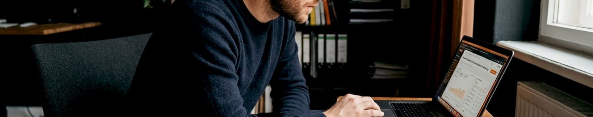 Ein Mann sitzt an seinem Schreibtisch und nimmt ein Amazon-Listing genau unter die Lupe.